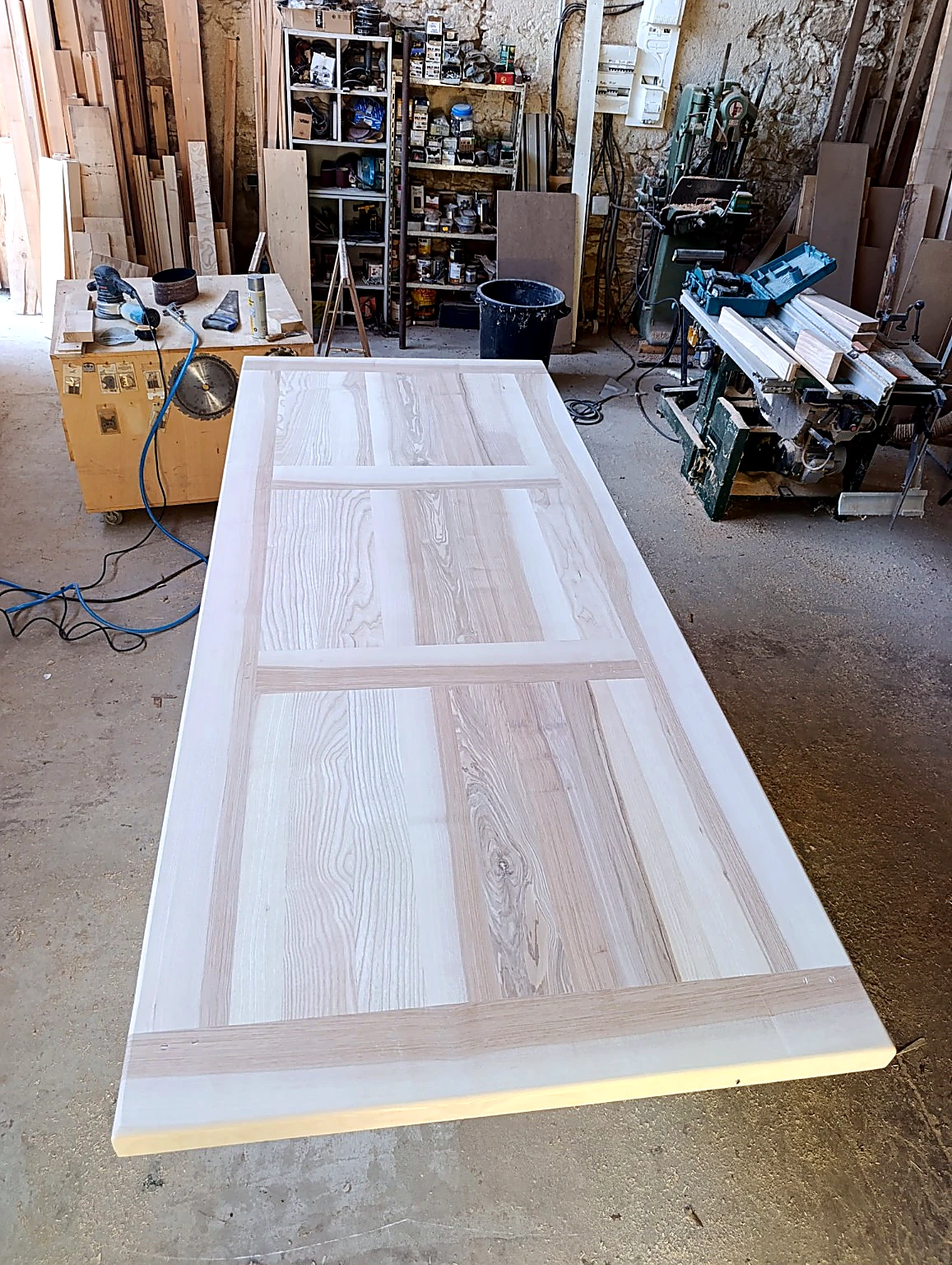 Grand plateau de table en bois massif dans un atelier de menuiserie