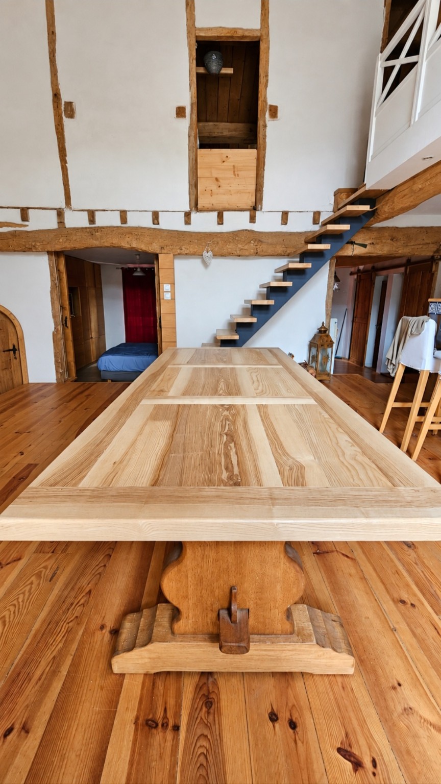 Grande table installée dans une maison avec un escalier en arrière-plan