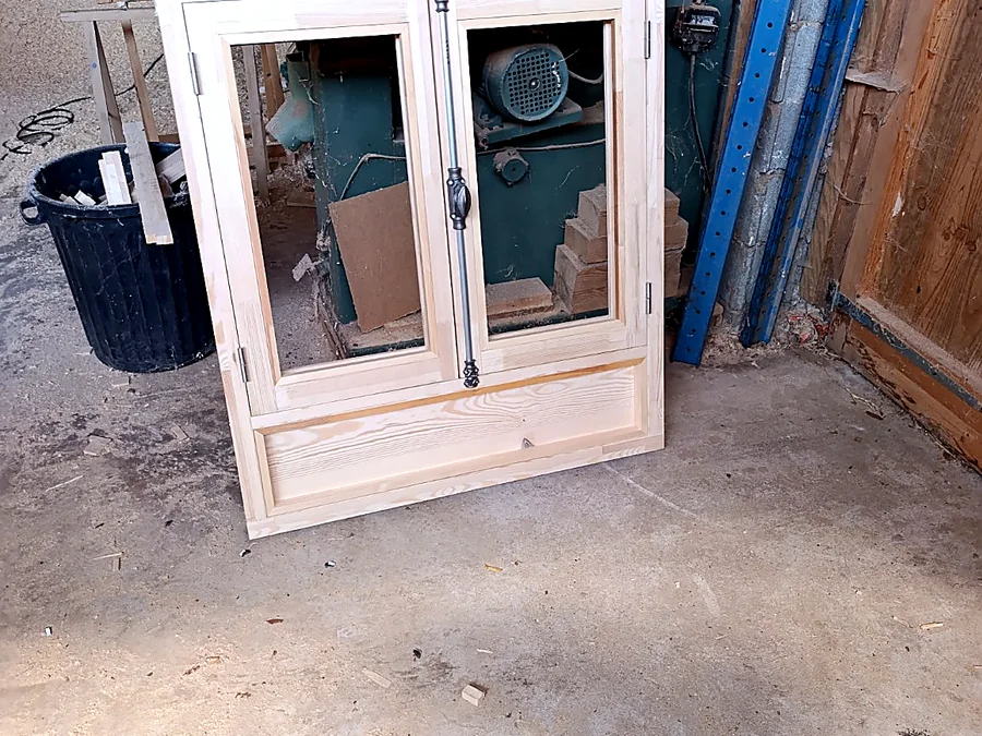 Fenêtre en bois clair avec quincaillerie traditionnelle