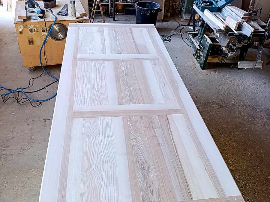 Grand plateau de table en bois massif dans un atelier de menuiserie