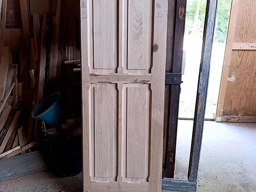 Porte artisanale à panneaux en bois clair