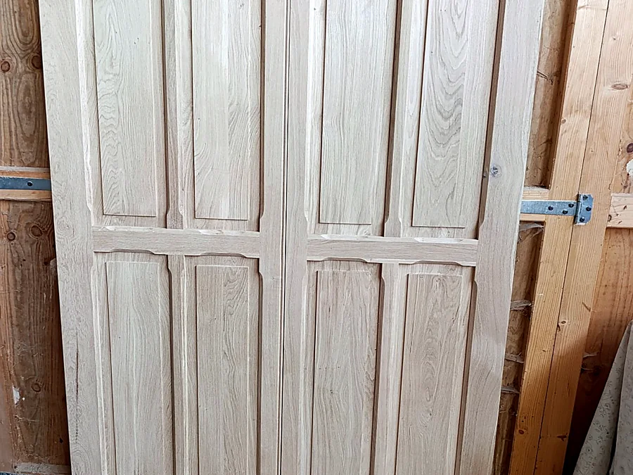 Deux portes à panneaux en bois clair vues de face